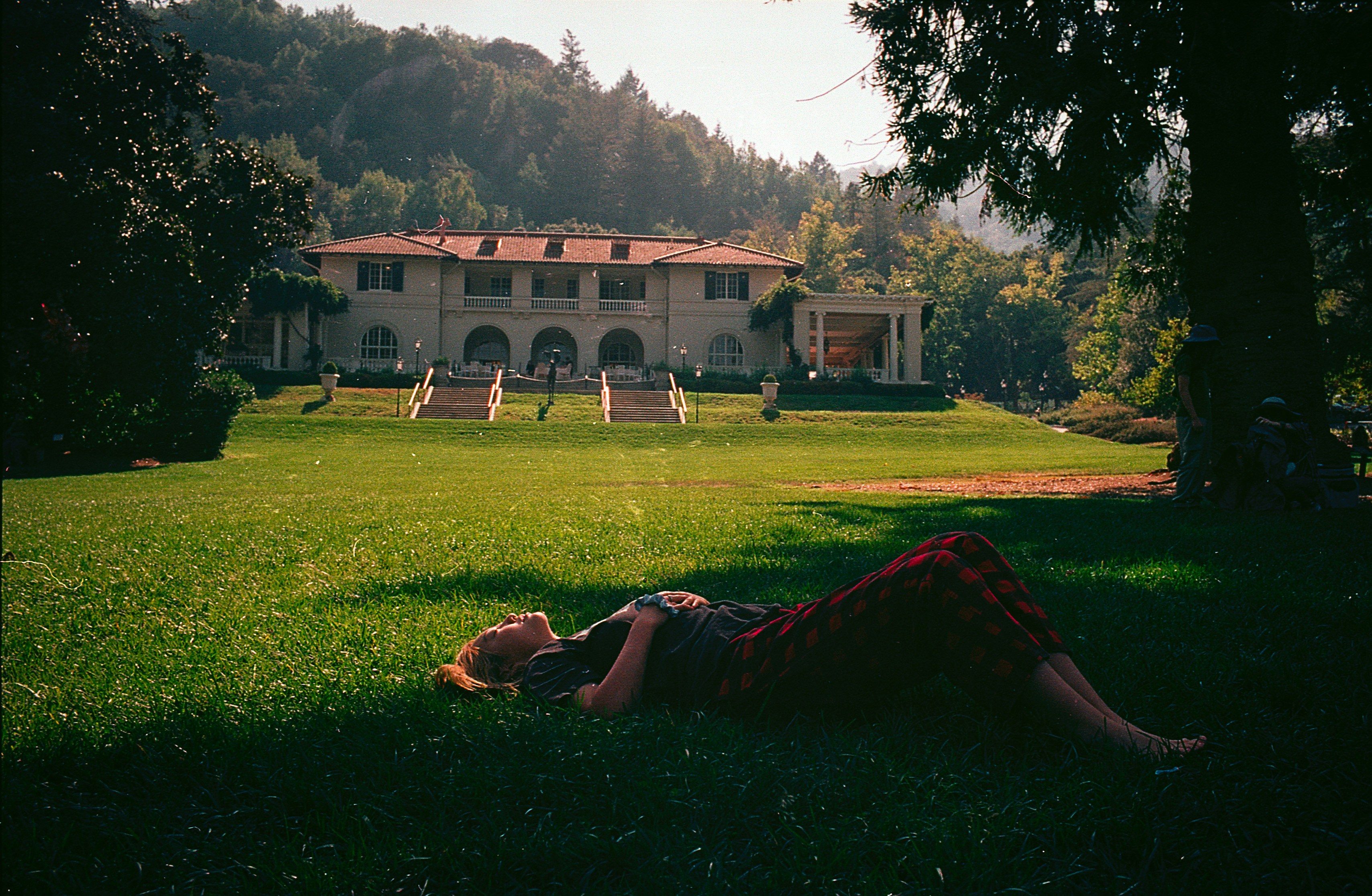 a person laying on the grass in front of a house