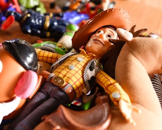 a toy cowboy laying on top of a wooden table