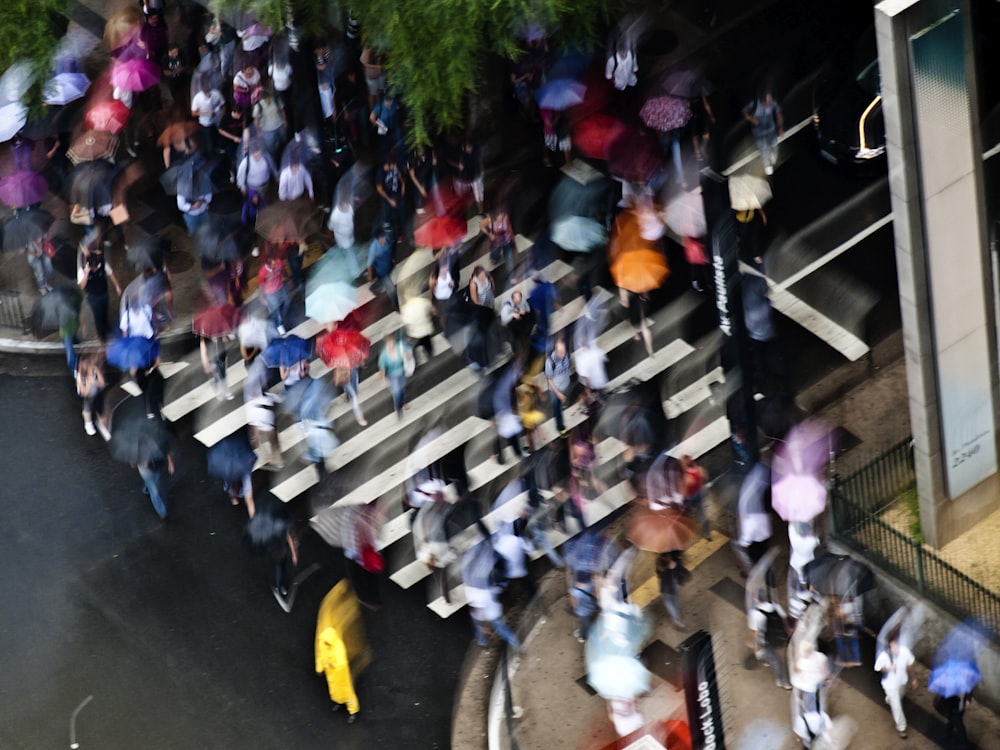 a crowd of people walking down a street holding umbrellas