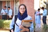 a woman in a hijab is holding a book