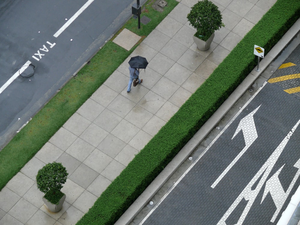 a person walking down a sidewalk with an umbrella