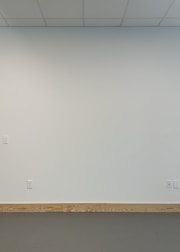 A clean, freshly painted wall with new trim and baseboards installed.