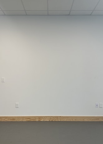 Interior view of a home with freshly finished drywall and electrical outlets installed.