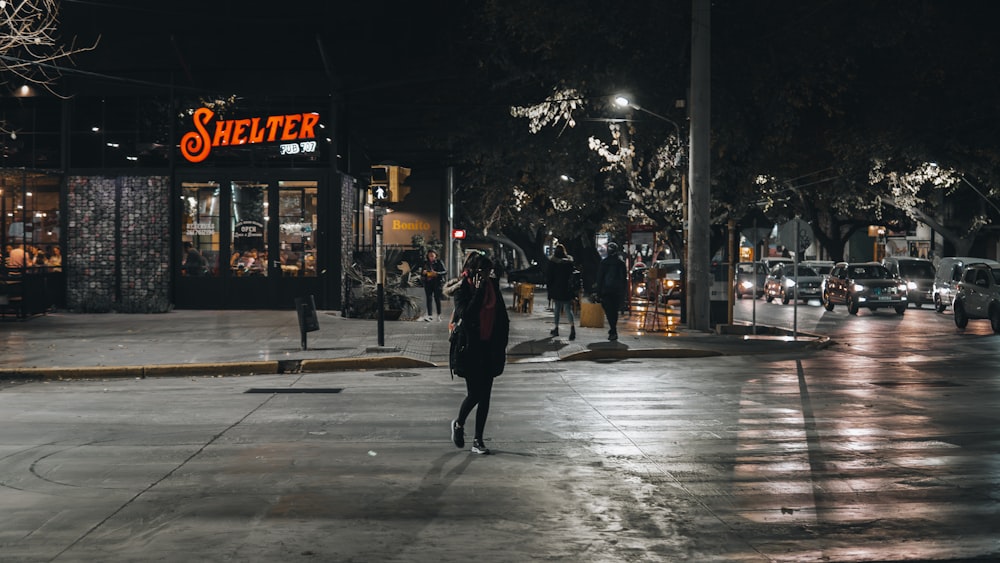 una mujer caminando por una calle de noche