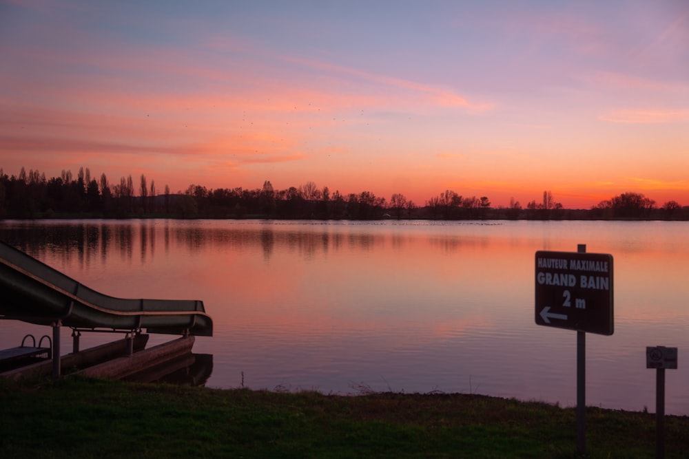 a lake with a slide next to it at sunset