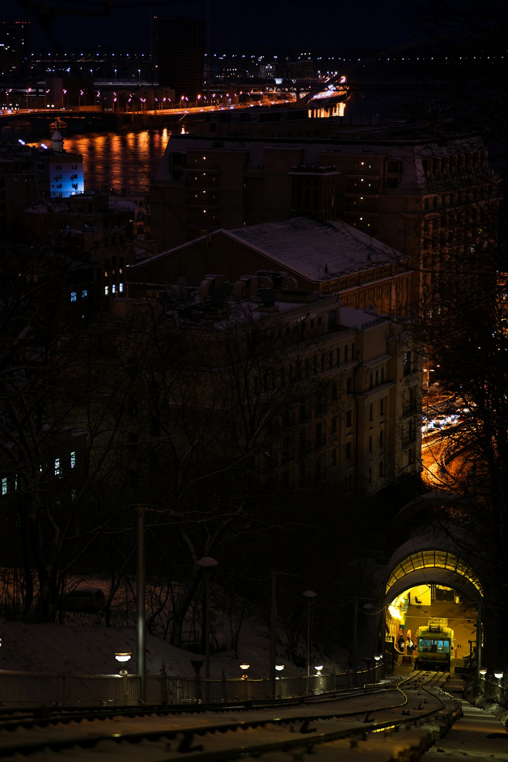 a city at night with a train on the tracks