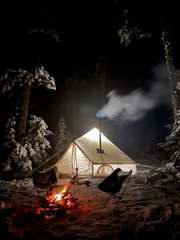 A cozy campfire with tents in the background.