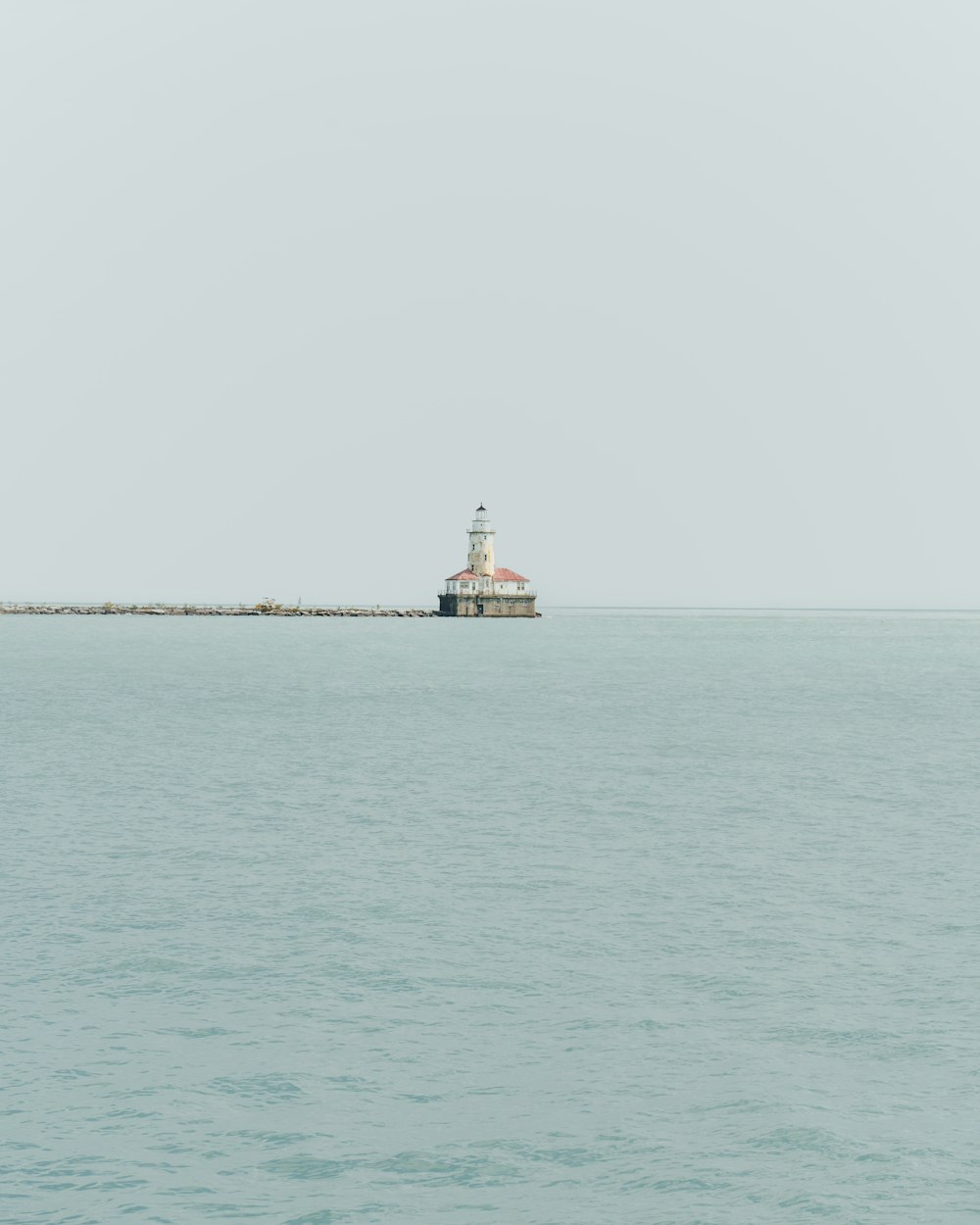 a light house sitting on top of a long pier