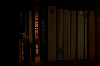 a bookshelf filled with lots of books in a dark room