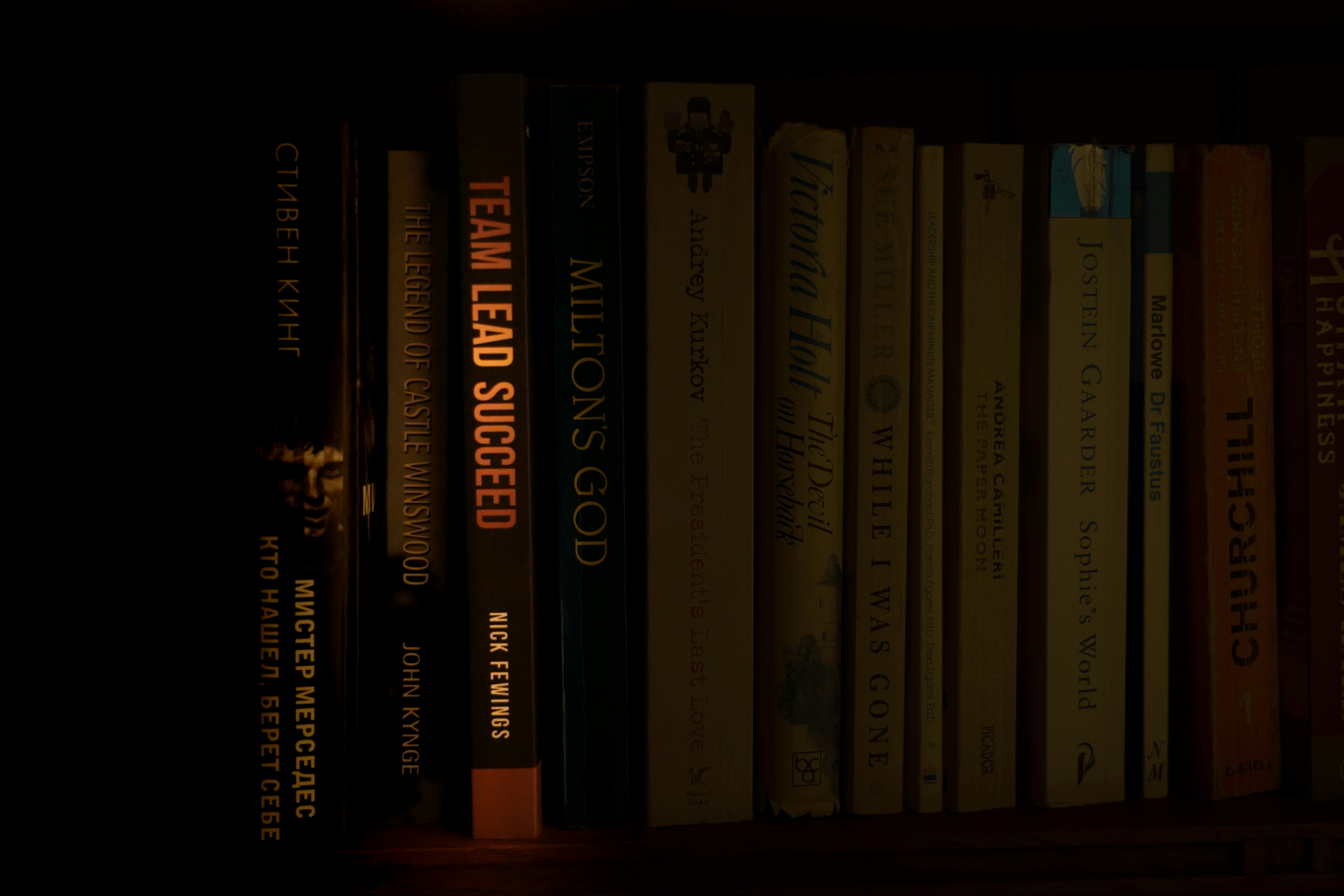 a bookshelf filled with lots of books in a dark room