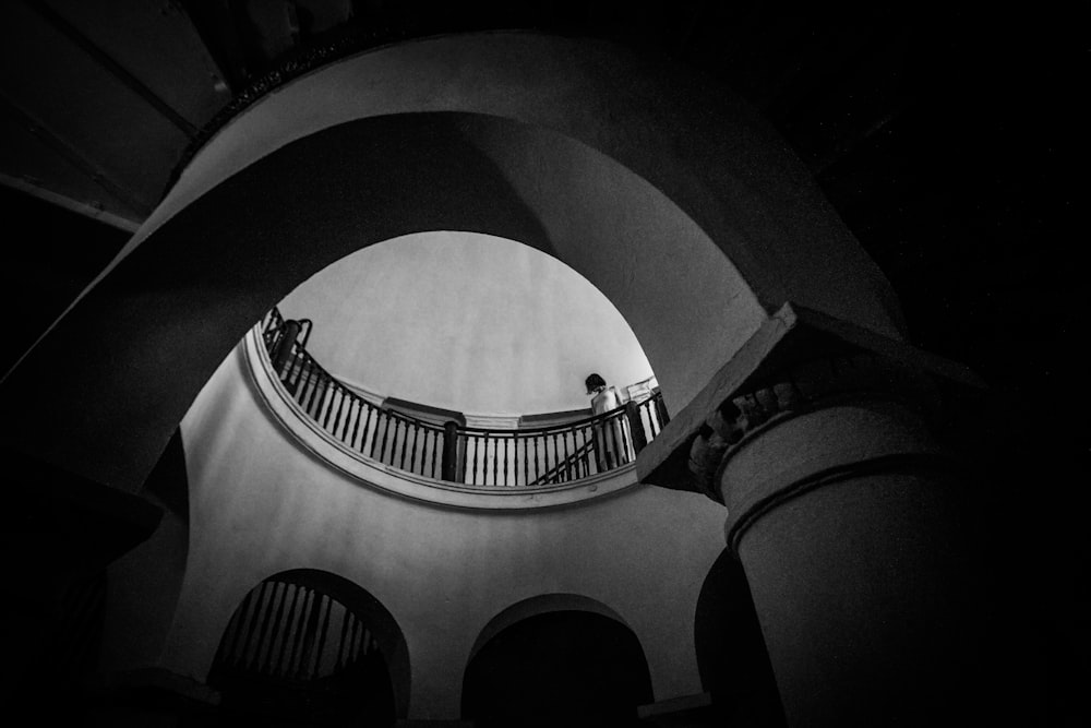 a black and white photo of a person on a balcony