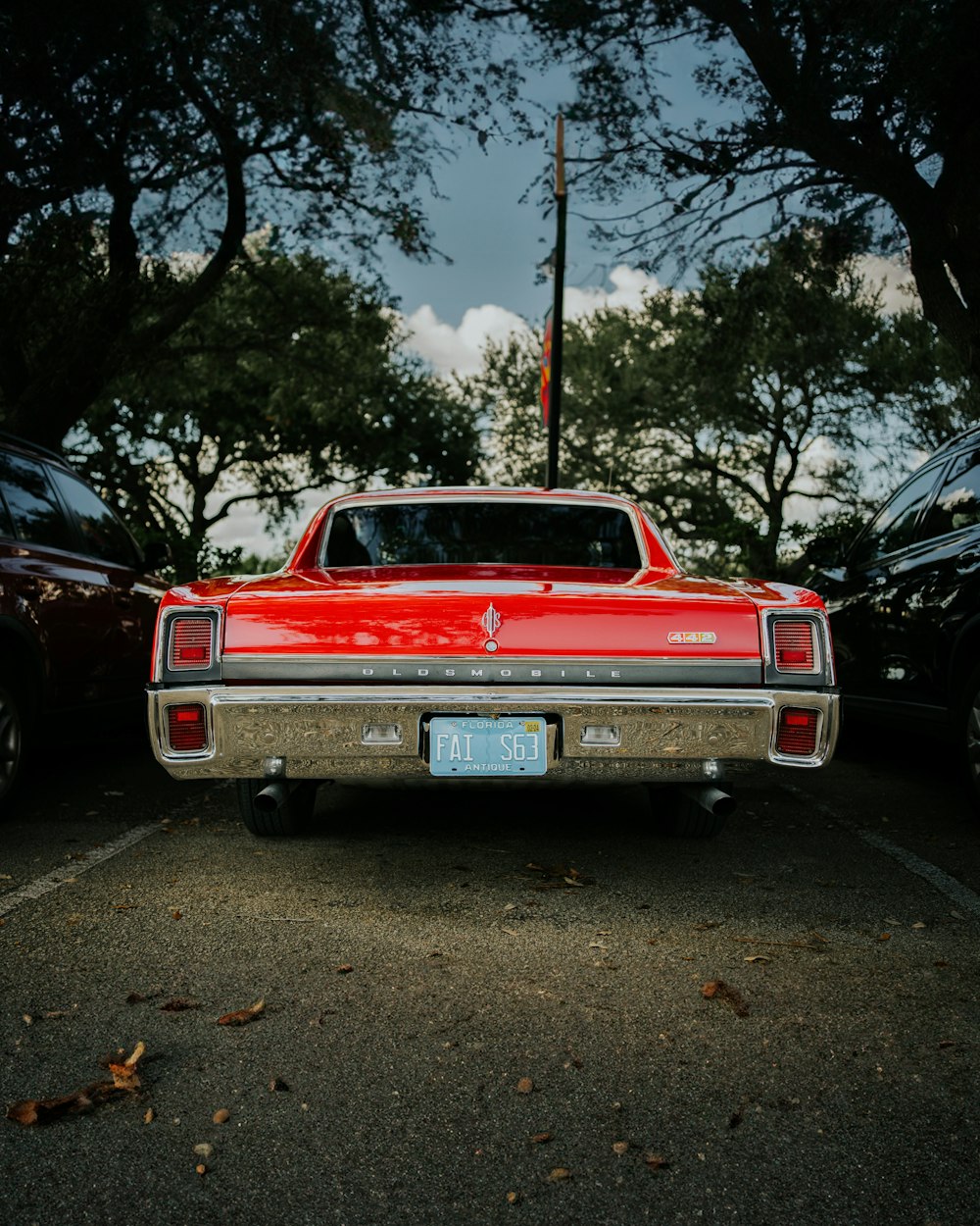 a red car is parked in a parking lot