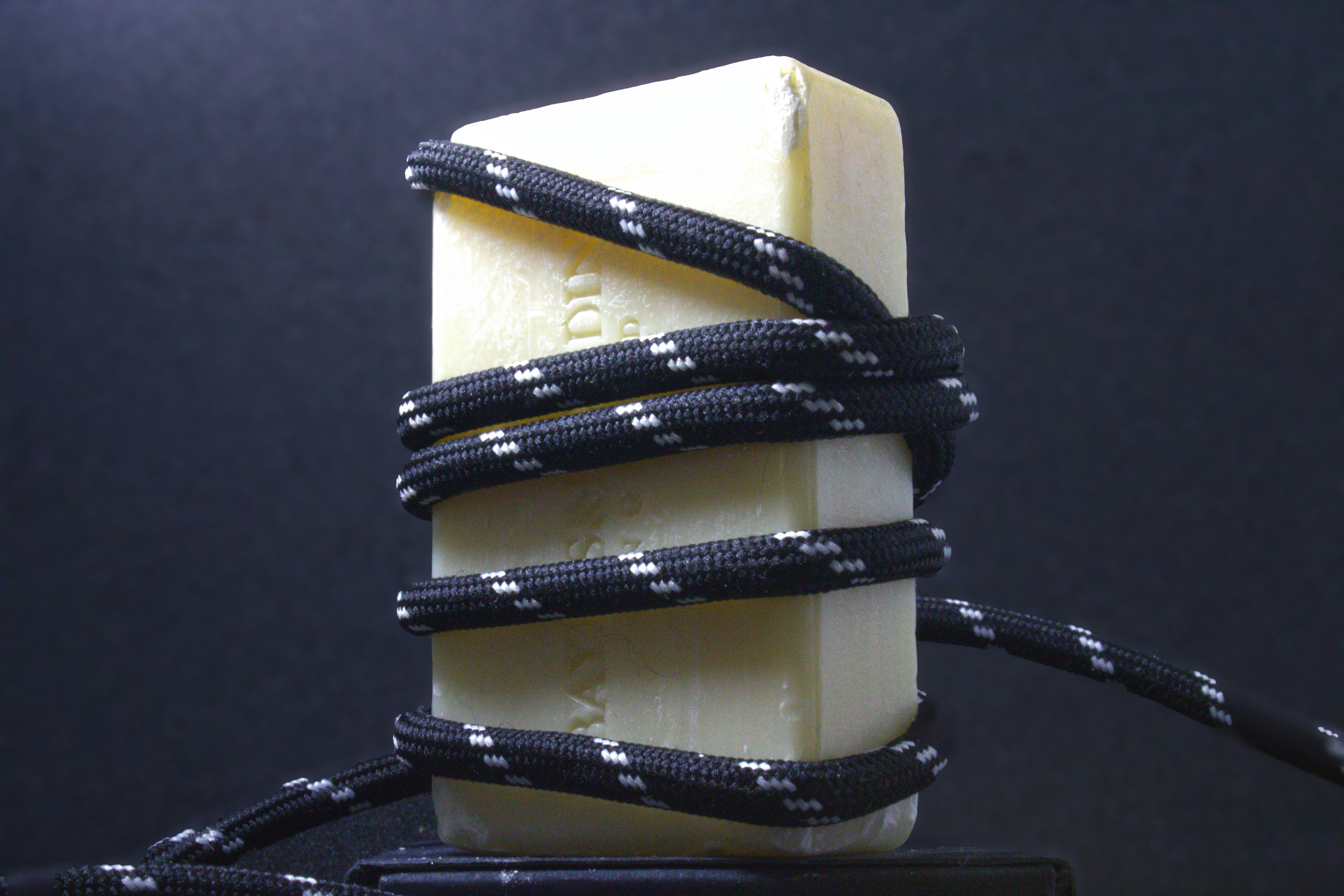 a block of cheese with a cord wrapped around it (Photo by leah knipe on Unsplash)