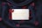 A bar of soap imprinted with 'Baylis & Harding England' placed on a black fabric background, surrounded by scattered red petals.