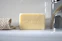 Smiling woman holding a bar of organic soap in a bright bathroom