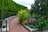 A beautifully landscaped garden featuring vibrant flowers, a stone pathway, and a cozy seating area.