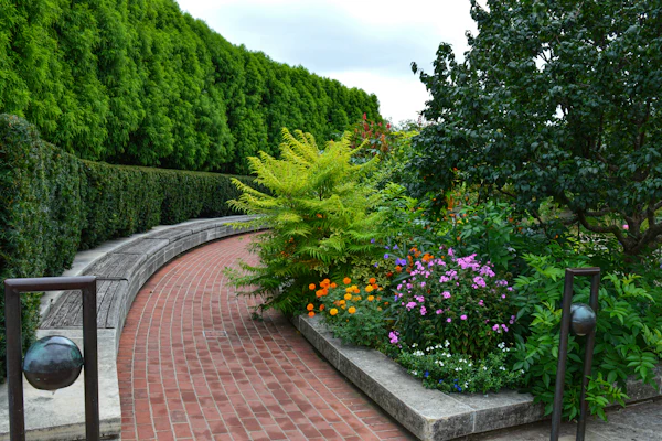 Brick paved path through a flower garden