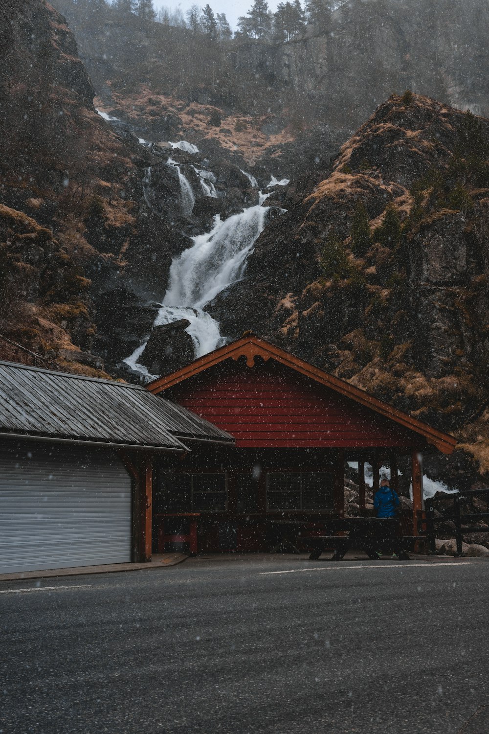 ein rotes Gebäude mit einem Wasserfall im Hintergrund