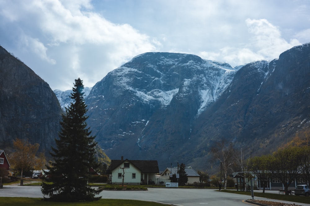 a mountain range with houses in the foreground and a snow covered mountain in the