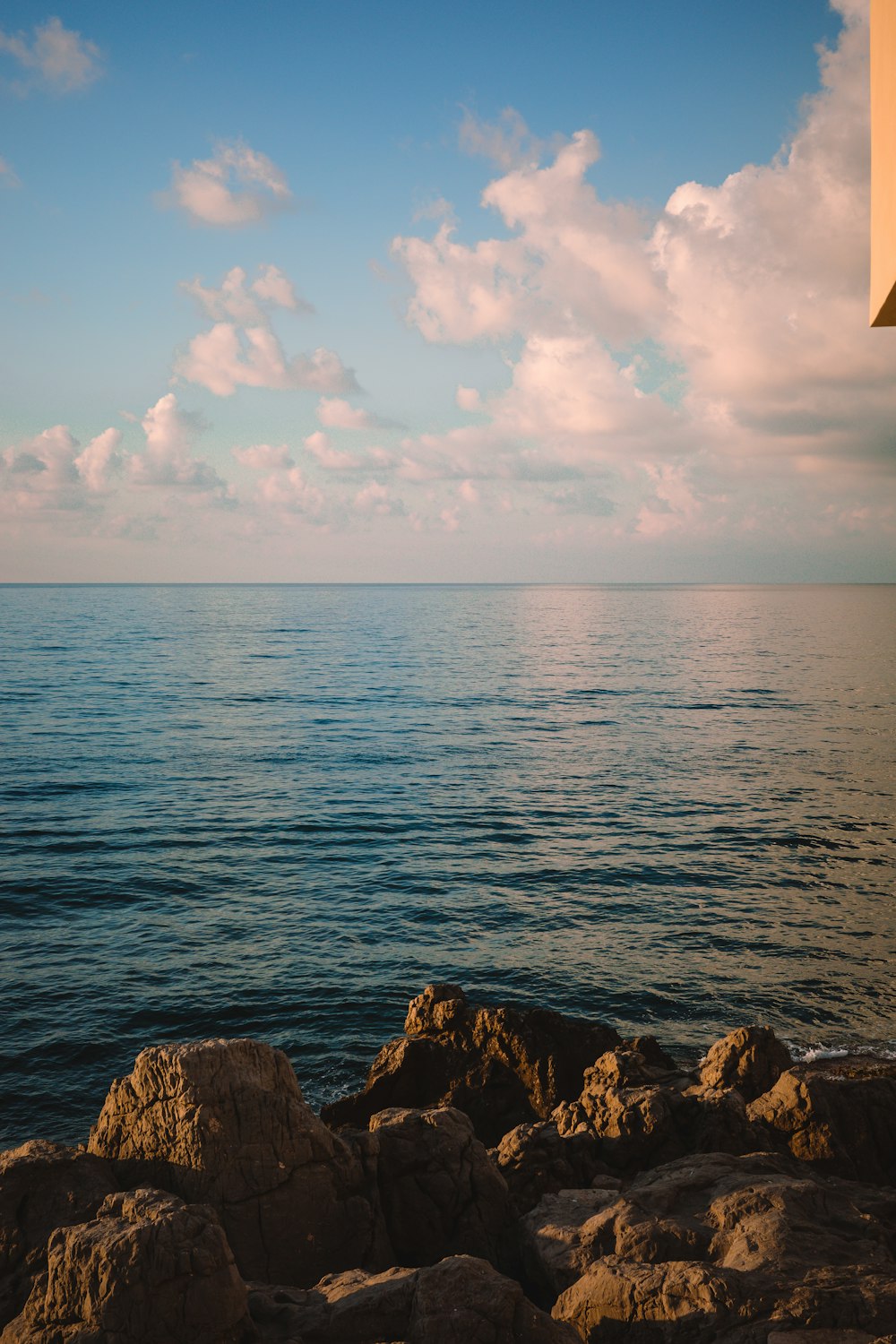 a large body of water sitting next to a rocky shore