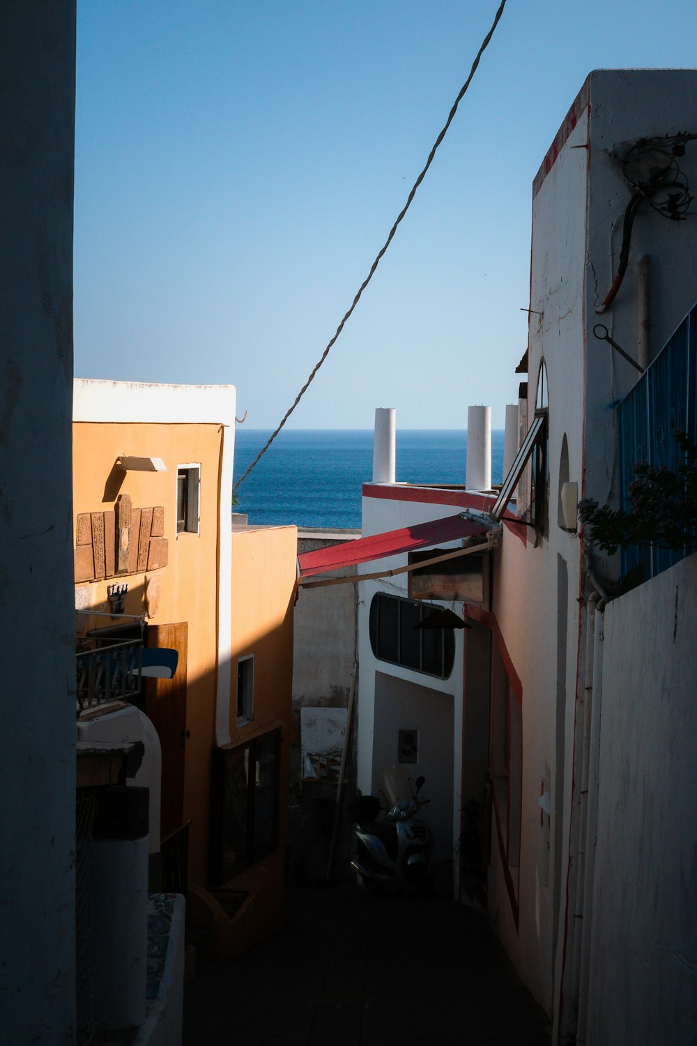 a narrow alley with a view of the ocean
