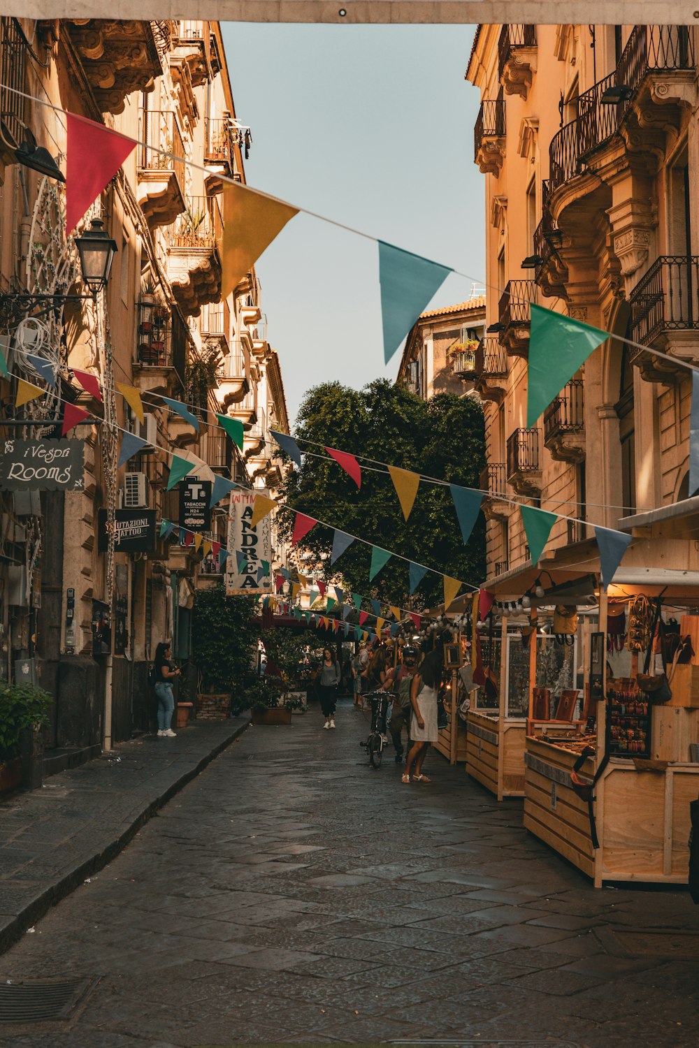 a narrow street lined with buildings and flags