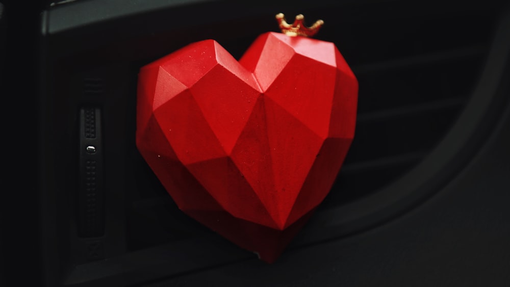 a red heart shaped object with a crown on top of it