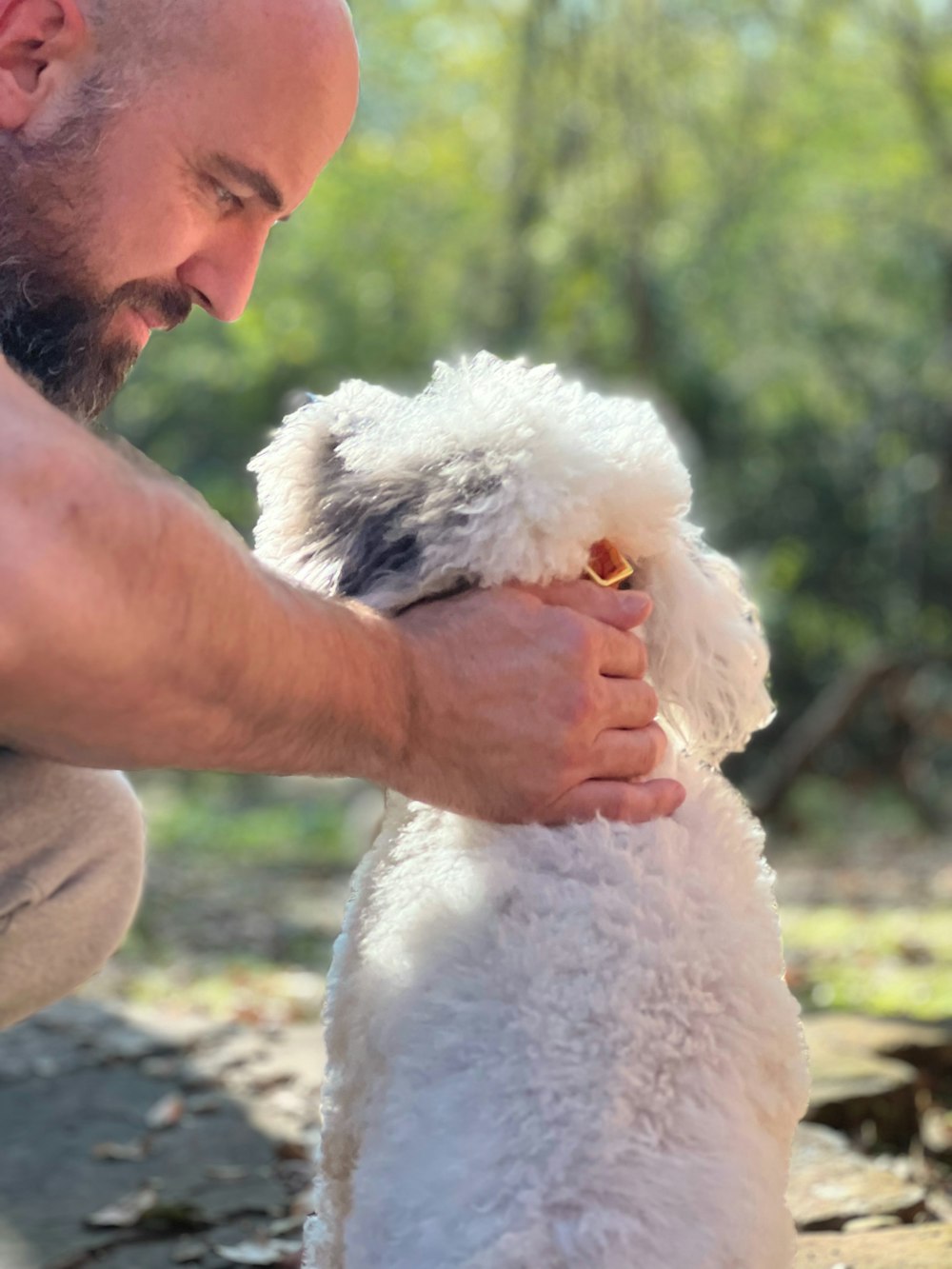 a man is petting a small white dog