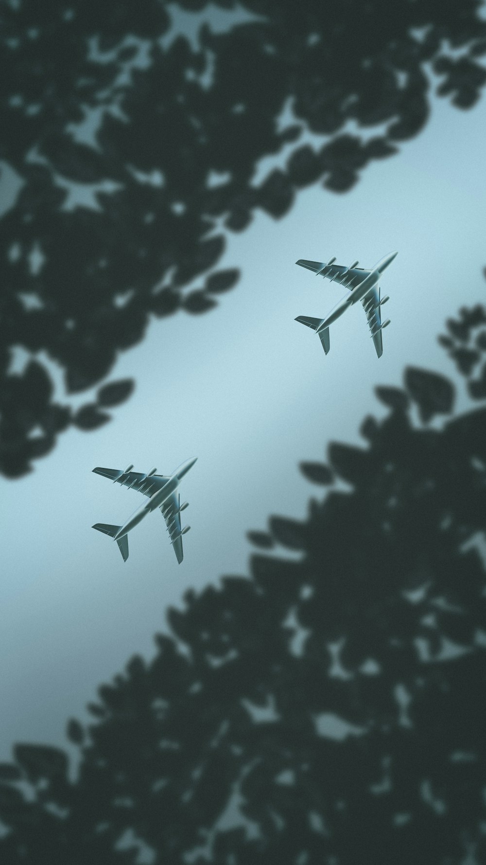 two airplanes flying in the sky above trees
