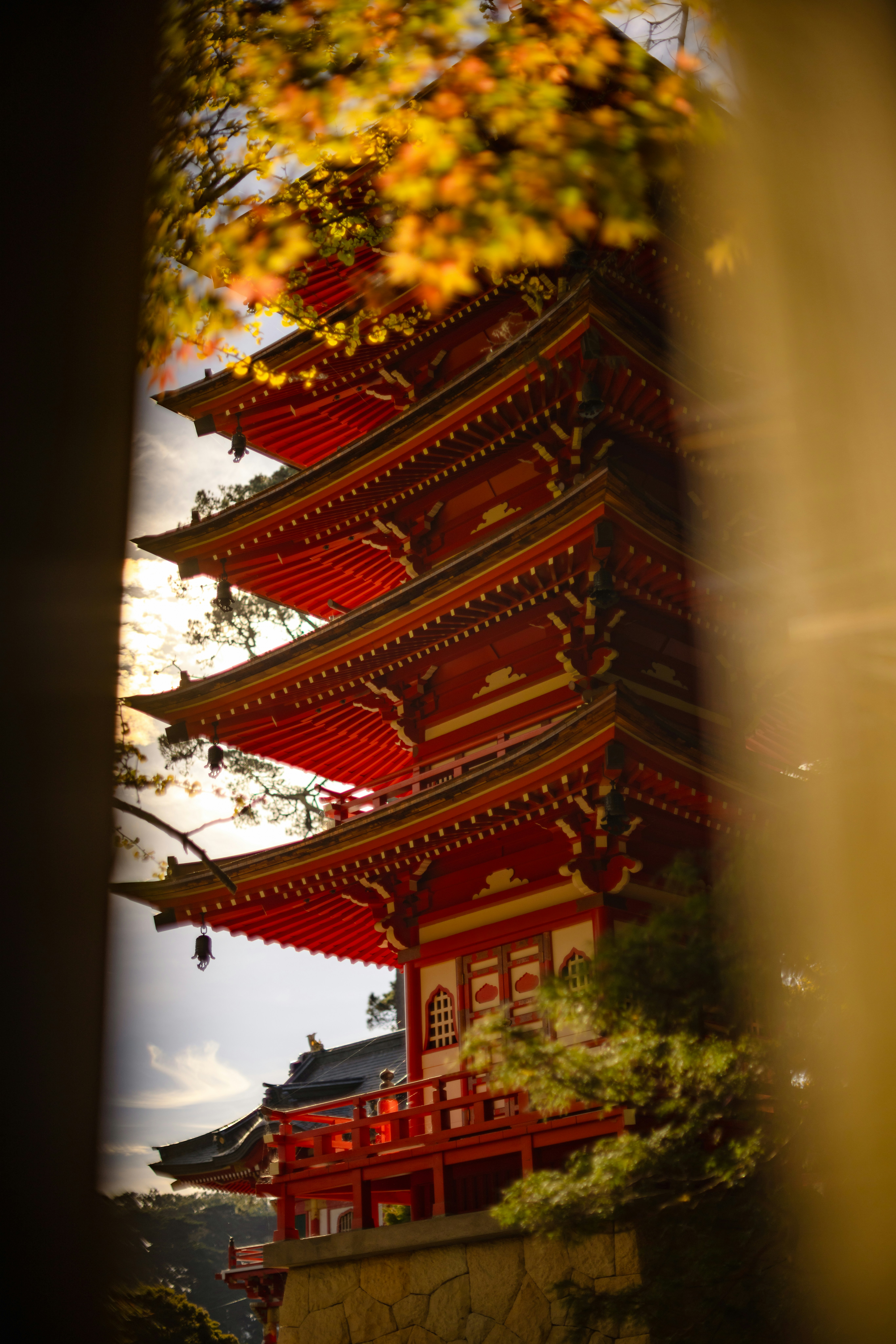a tall red building sitting next to a forest