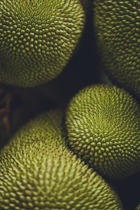 a bunch of green fruit sitting on top of each other