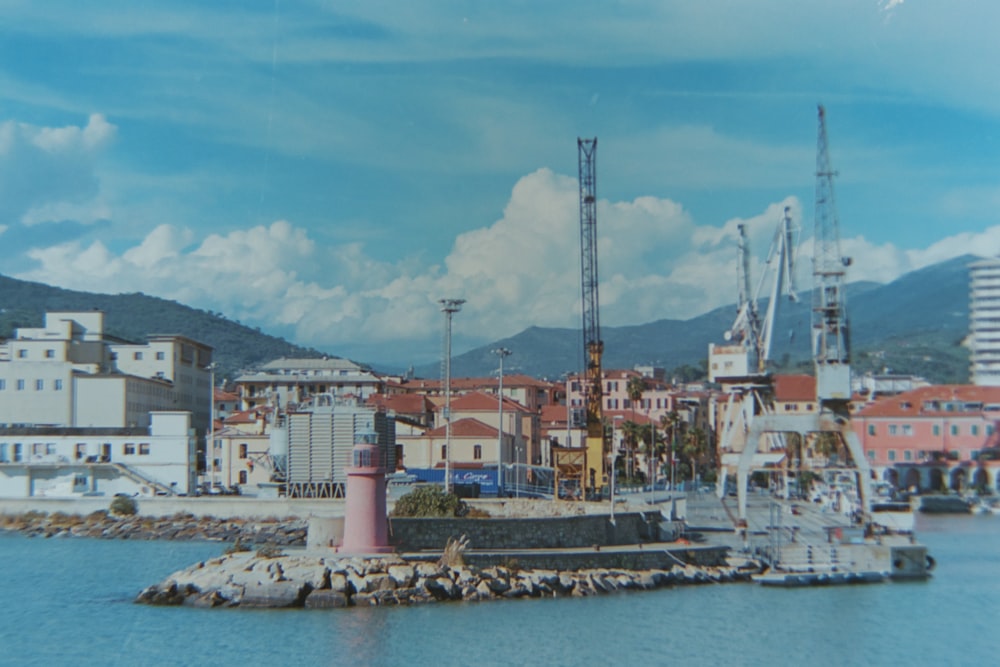 a picture of a harbor with a lighthouse in the foreground