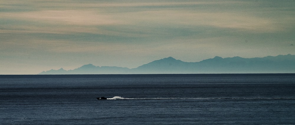 a small boat in the middle of a large body of water