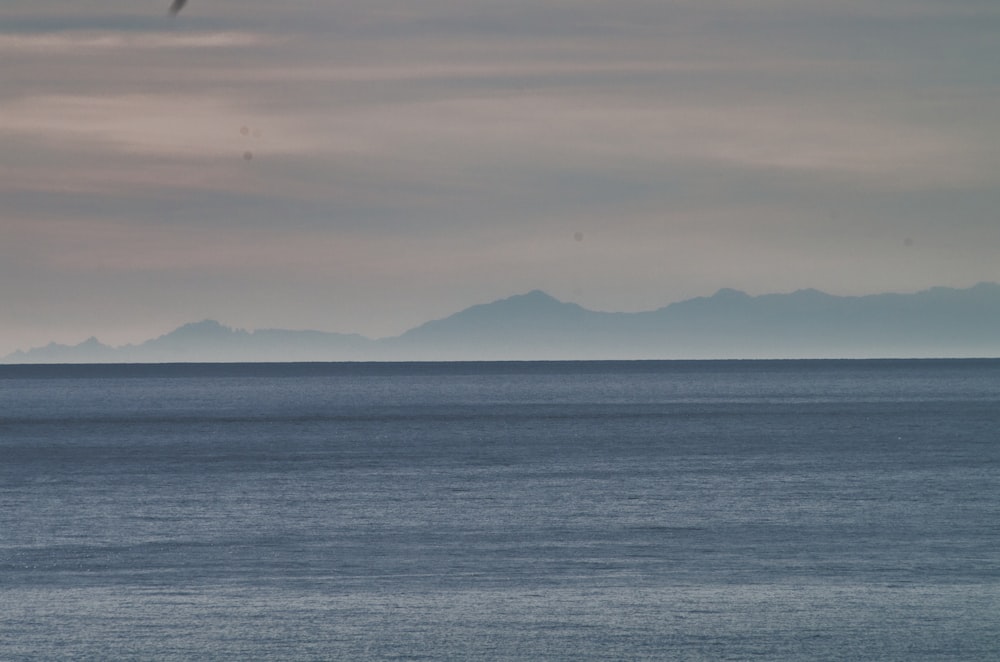 una gran masa de agua con montañas al fondo