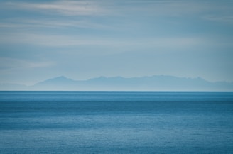 a large body of water with mountains in the background