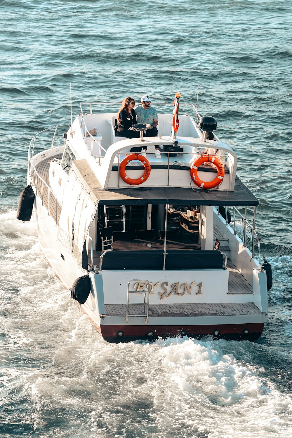 a white boat with people on it in the water