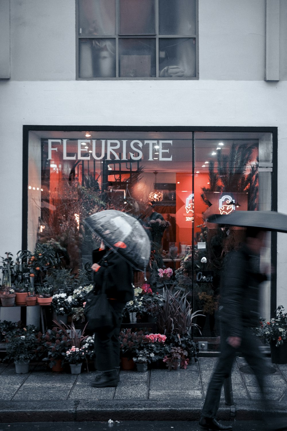 a couple of people walking down a street holding umbrellas