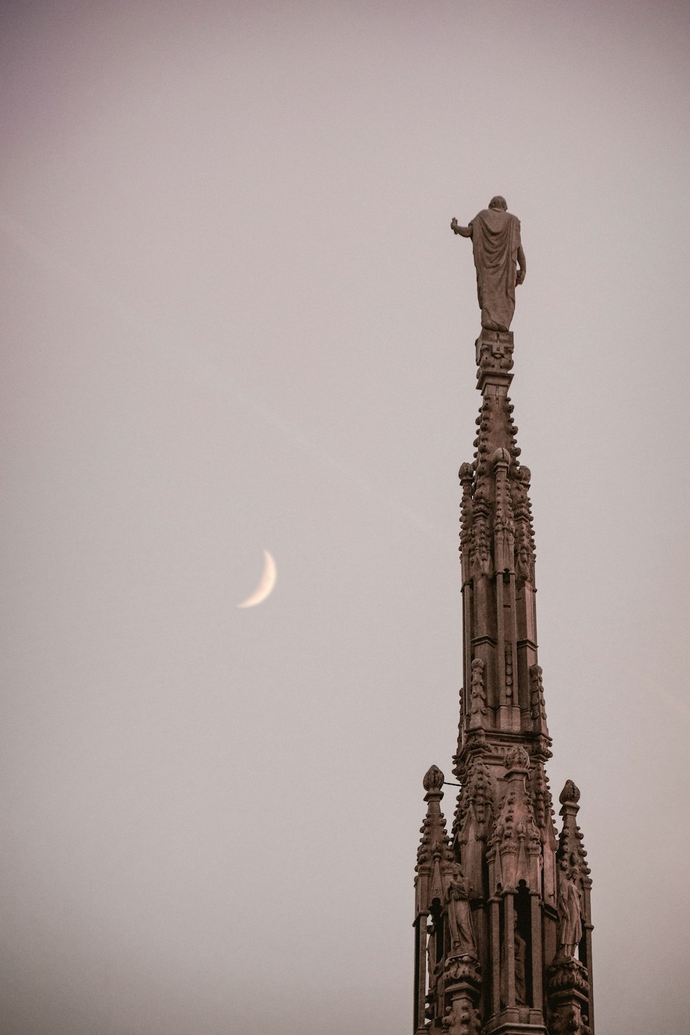 a tall tower with a statue on top of it