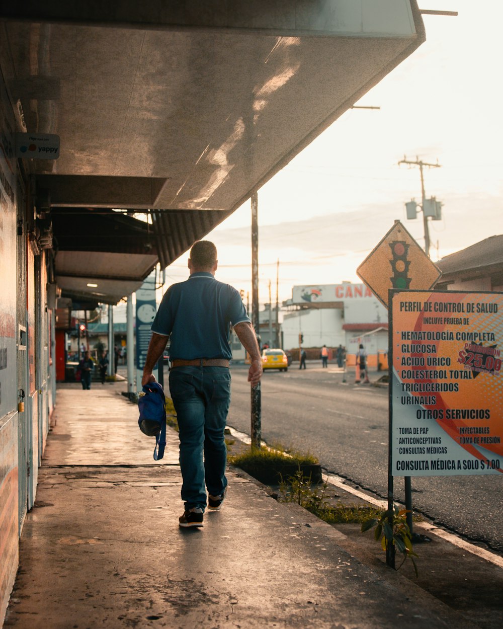 Un hombre caminando por una acera junto a un edificio