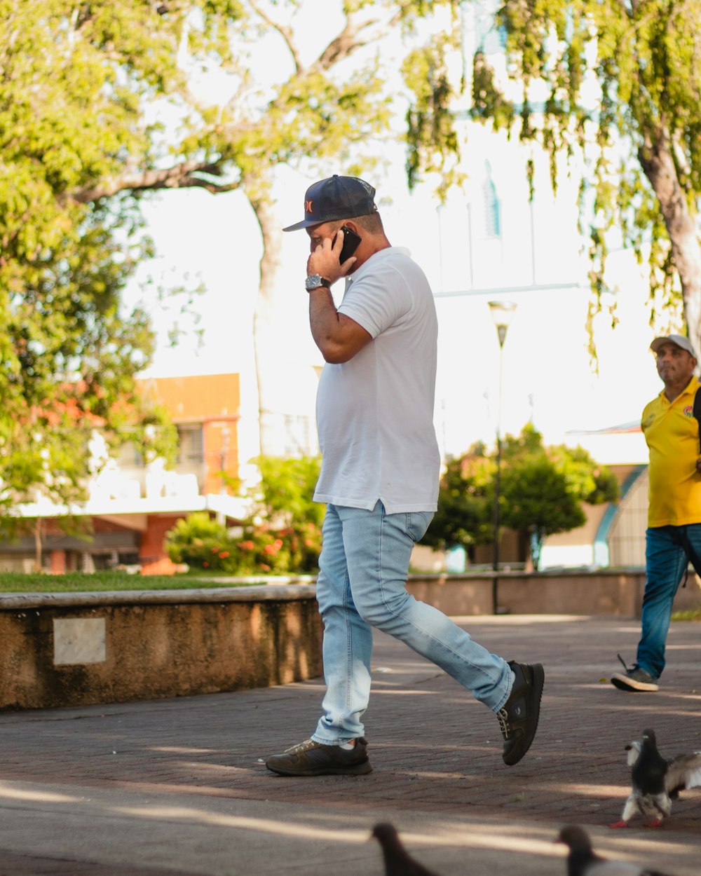 Un hombre caminando mientras habla por teléfono celular
