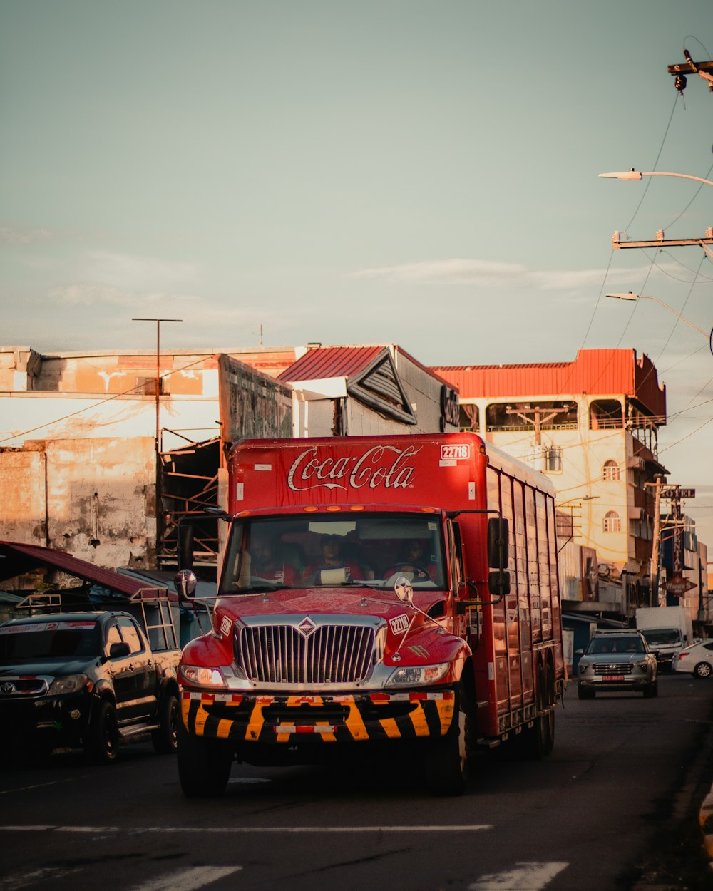 빨간 코카콜라 트럭이 거리를 달리고 있다