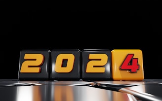 The image features the numbers 2024 in a block style, with each digit on a separate cube. The cubes have a glossy finish with a predominantly black and yellow color scheme. The number '4' is highlighted in bright yellow with a red outline, contrasting with the black background.