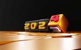 Golden numbers represent the year 2024 on a smooth reflective surface. Each digit is displayed on a cube, with the final number standing out in red.