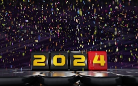 Colored blocks displaying the numbers 2024 are set against a dark background with vibrant confetti falling around them, creating a festive atmosphere.