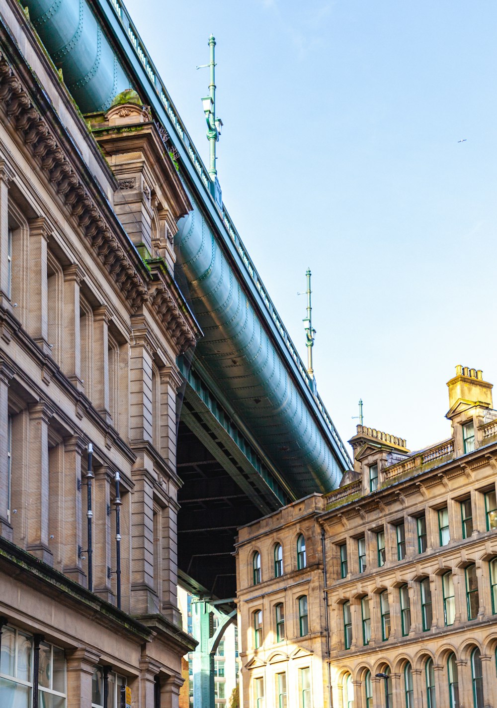 a train is going over a bridge over some buildings