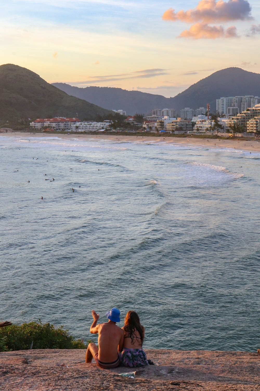 a couple of people sitting on top of a beach