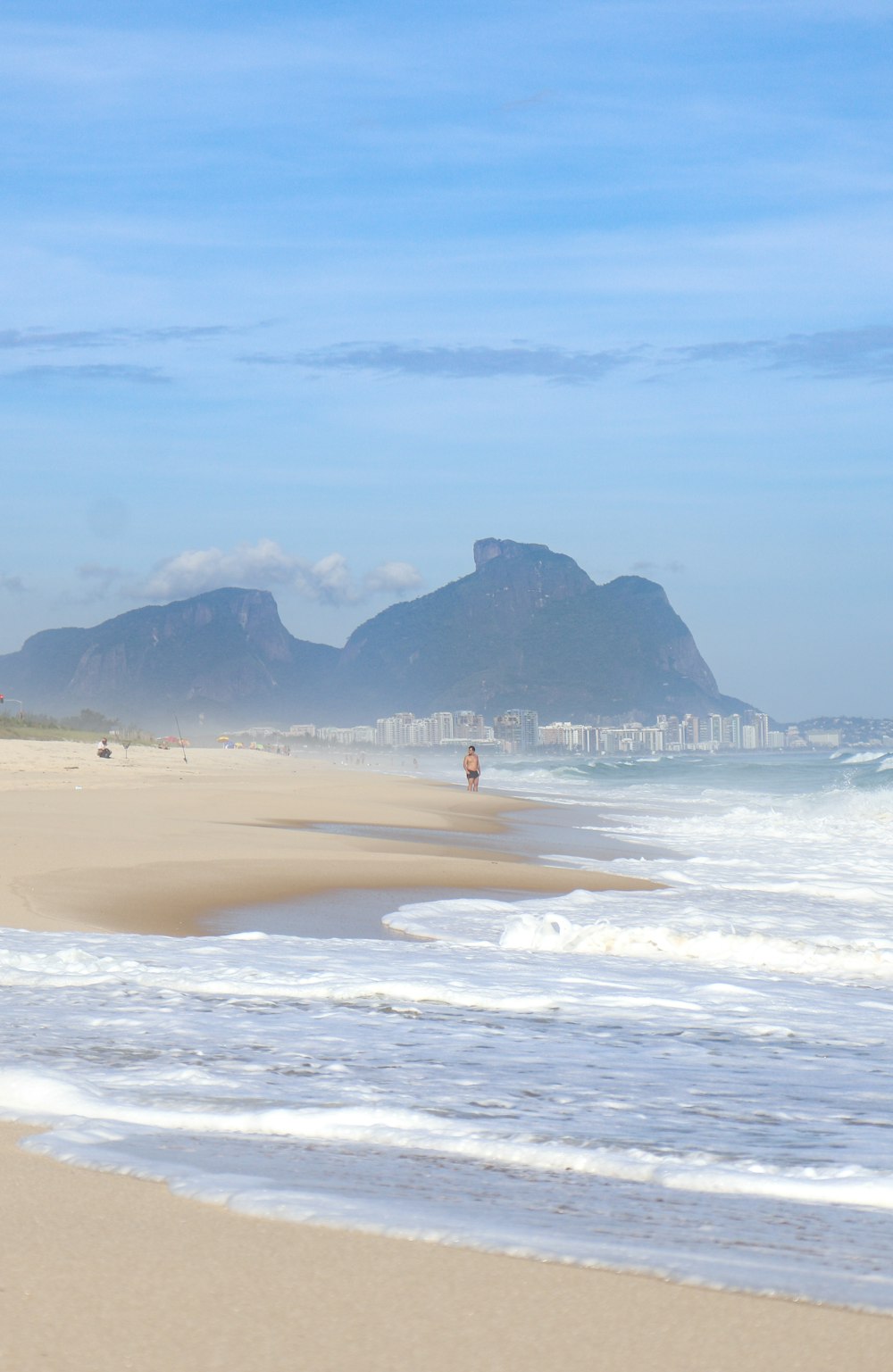 a person standing on a beach next to the ocean