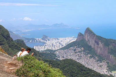 a couple of people sitting on top of a mountain