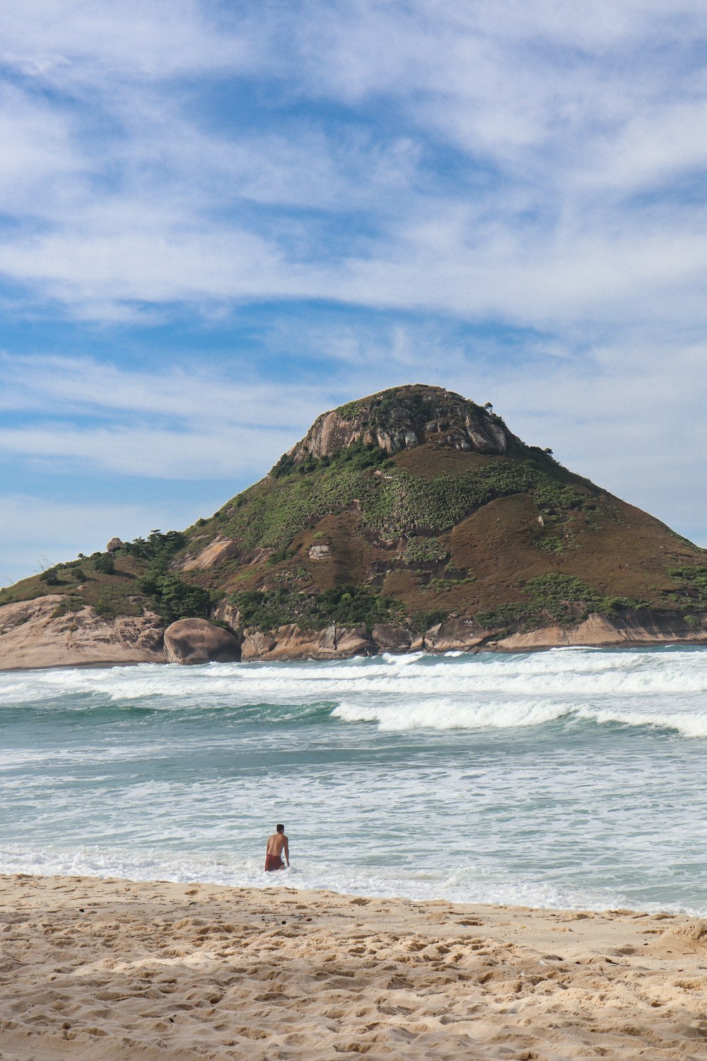 a person sitting on a beach next to the ocean