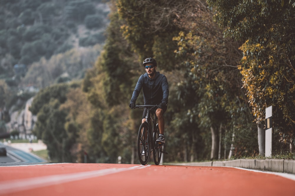 a man riding a bike down a red road